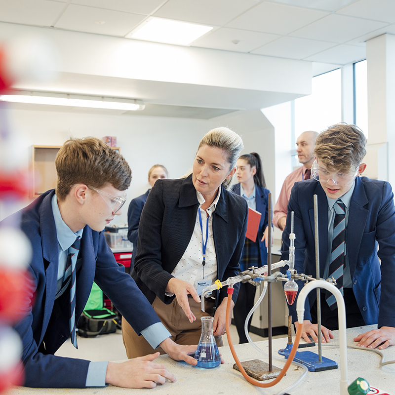 Teacher and two students completing a science experiment