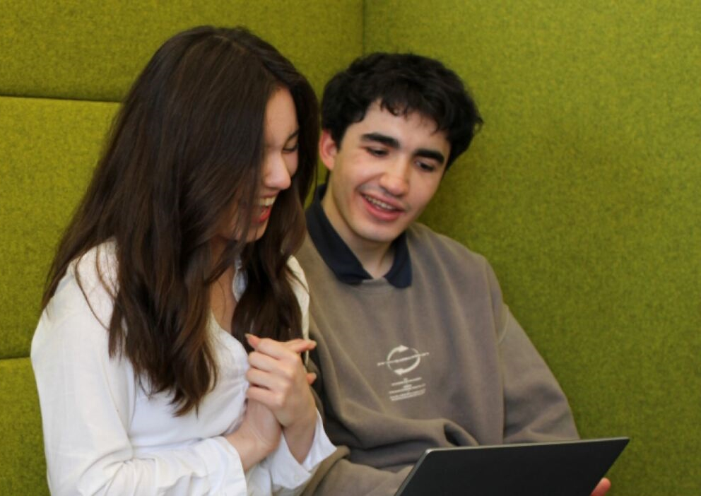 a man and a woman sat on a green sofa