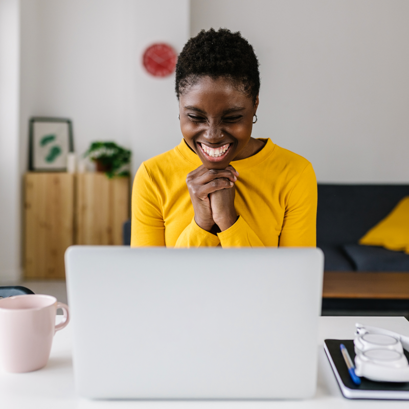 Researcher excited and smiling at her laptop