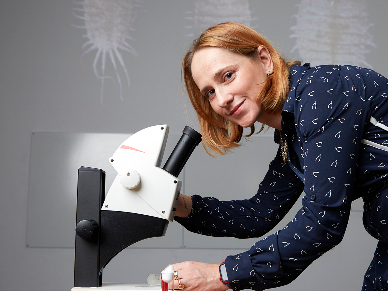 a woman looking into a microscope