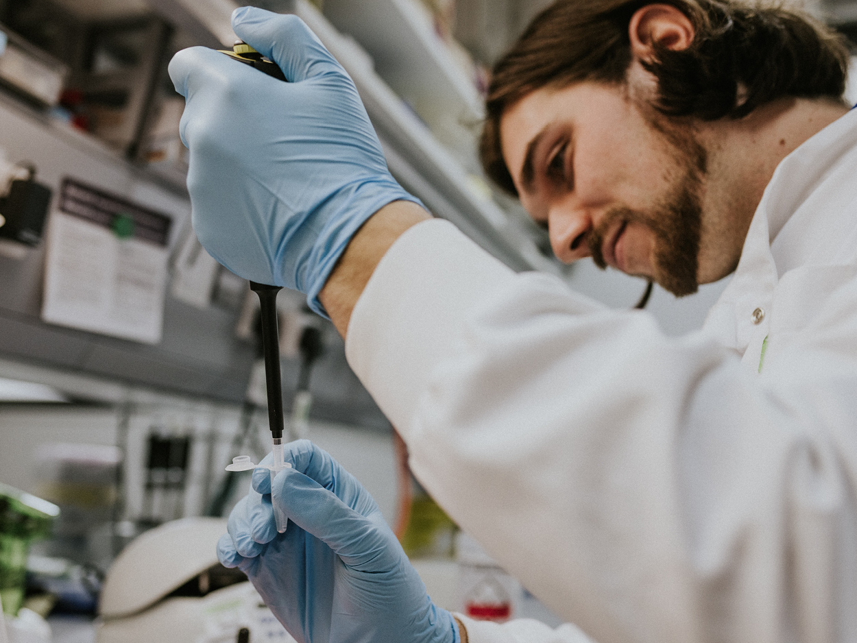 bearded man in a lab using a pipette