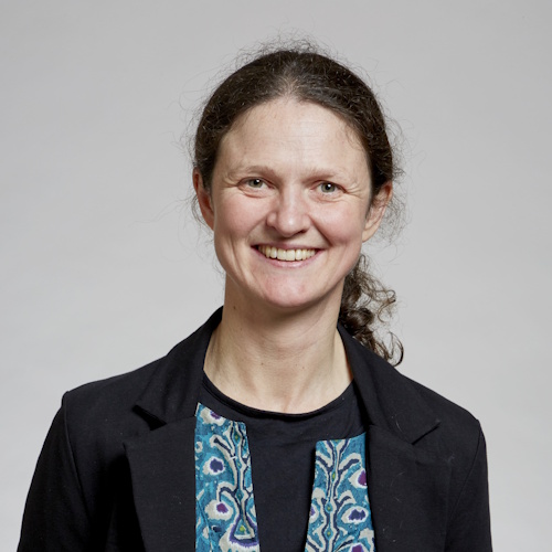 Dr Amy Bonsor wearing a navy blazer against a grey background